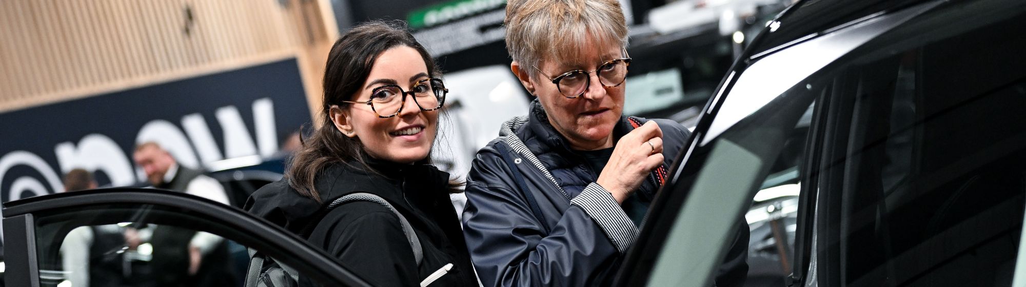 Deux visiteurs sur Foire de Paris qui essaient une voiture neuve