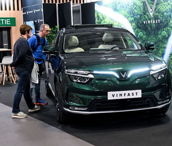Des visiteurs qui regardent une voiture neuve sur un stand de Foire de Paris