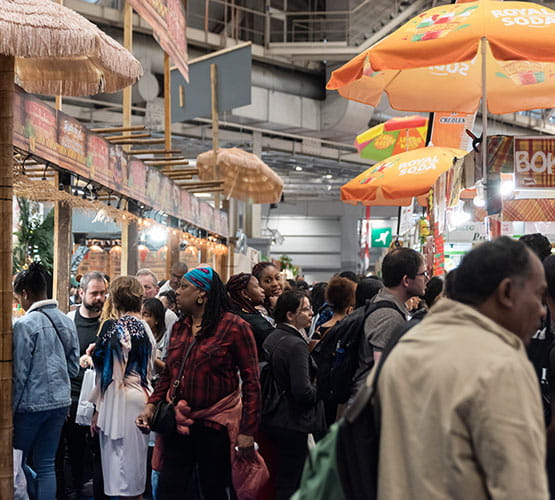 visiteurs dans les allées entre les stands d'achards de morue et de bokits