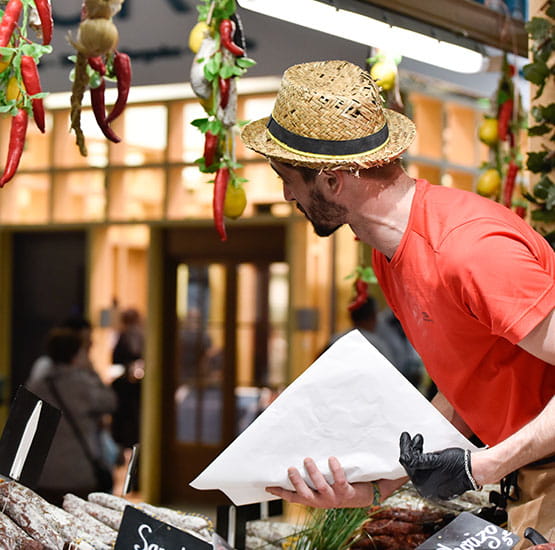 marchand de saucissons vendant son produit face au client
