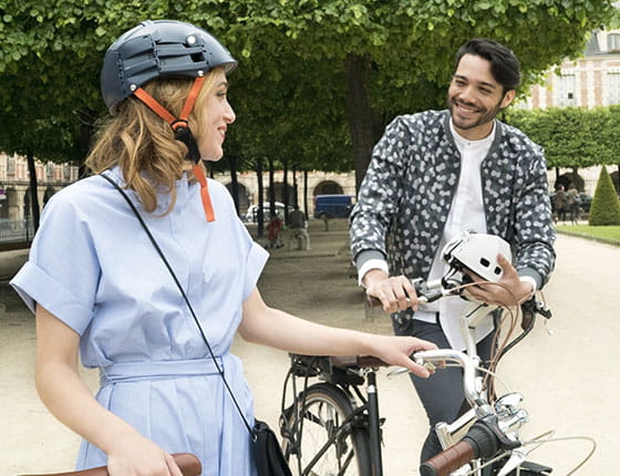 personnes à vélo et portant un casque, passant un bon moment sur la place des Vosges
