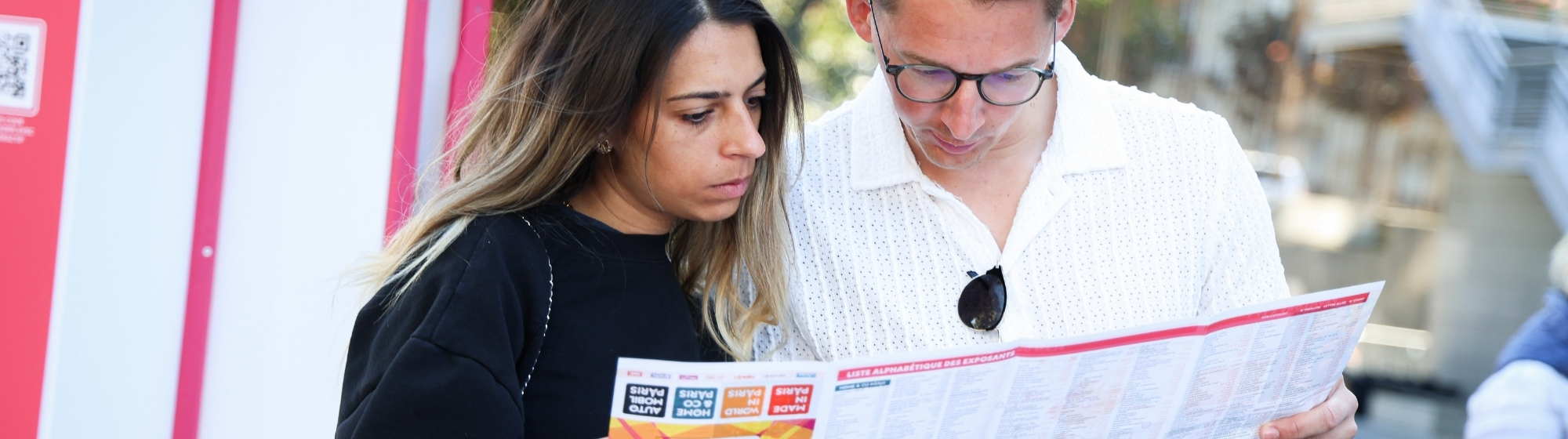 un homme et une femme regardant le plan papier du salon