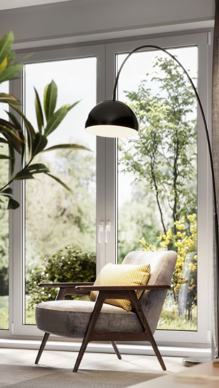 Fauteuil moderne avec un lampadaire arc dans un salon lumineux avec vue sur l'extérieur.