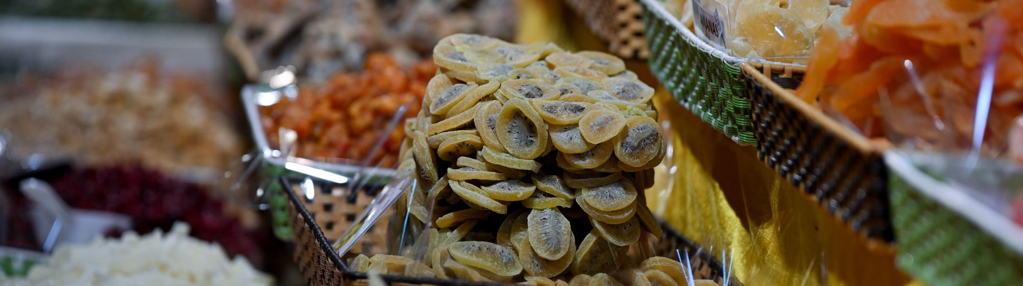 Étal de fruits secs et spécialités alimentaires variées sur un marché.